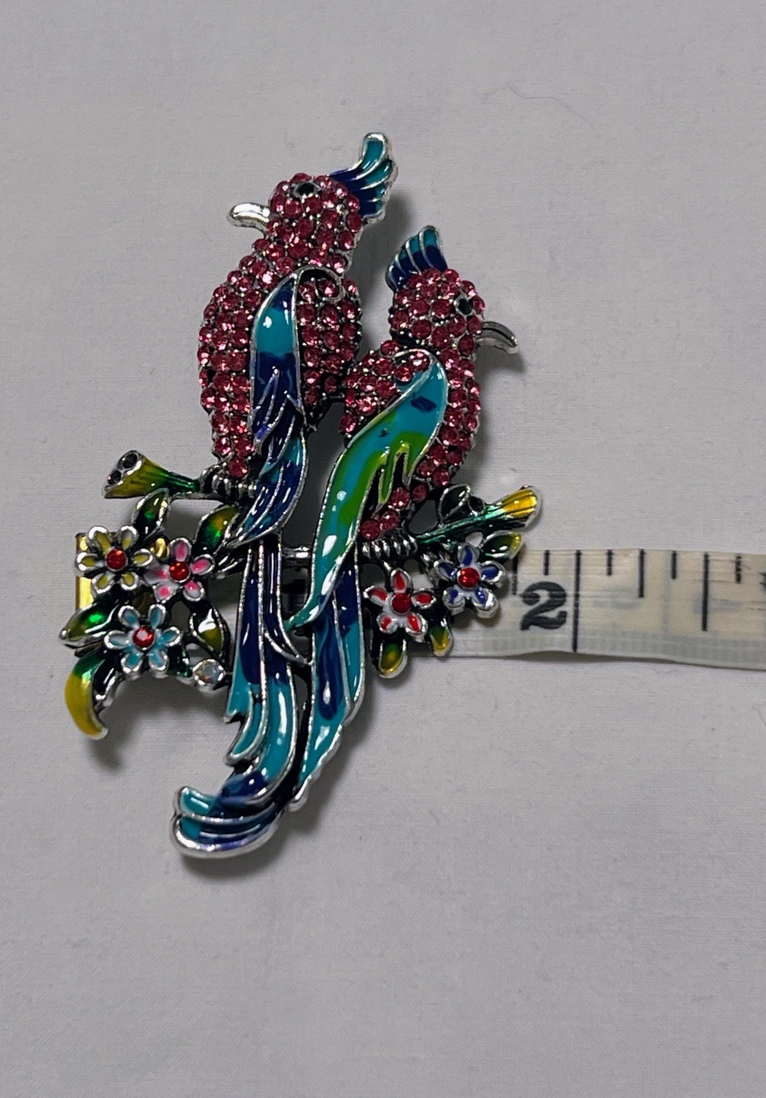 Pink rhinestone green blue enamel Birds of Paradise pin brooch sitting on flower