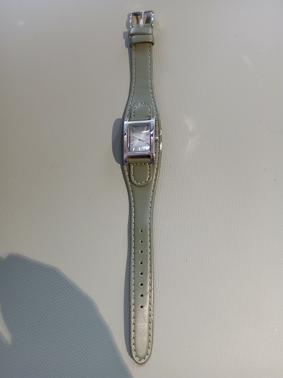 Ladies silver wathch with green face and one piece strap, new battery