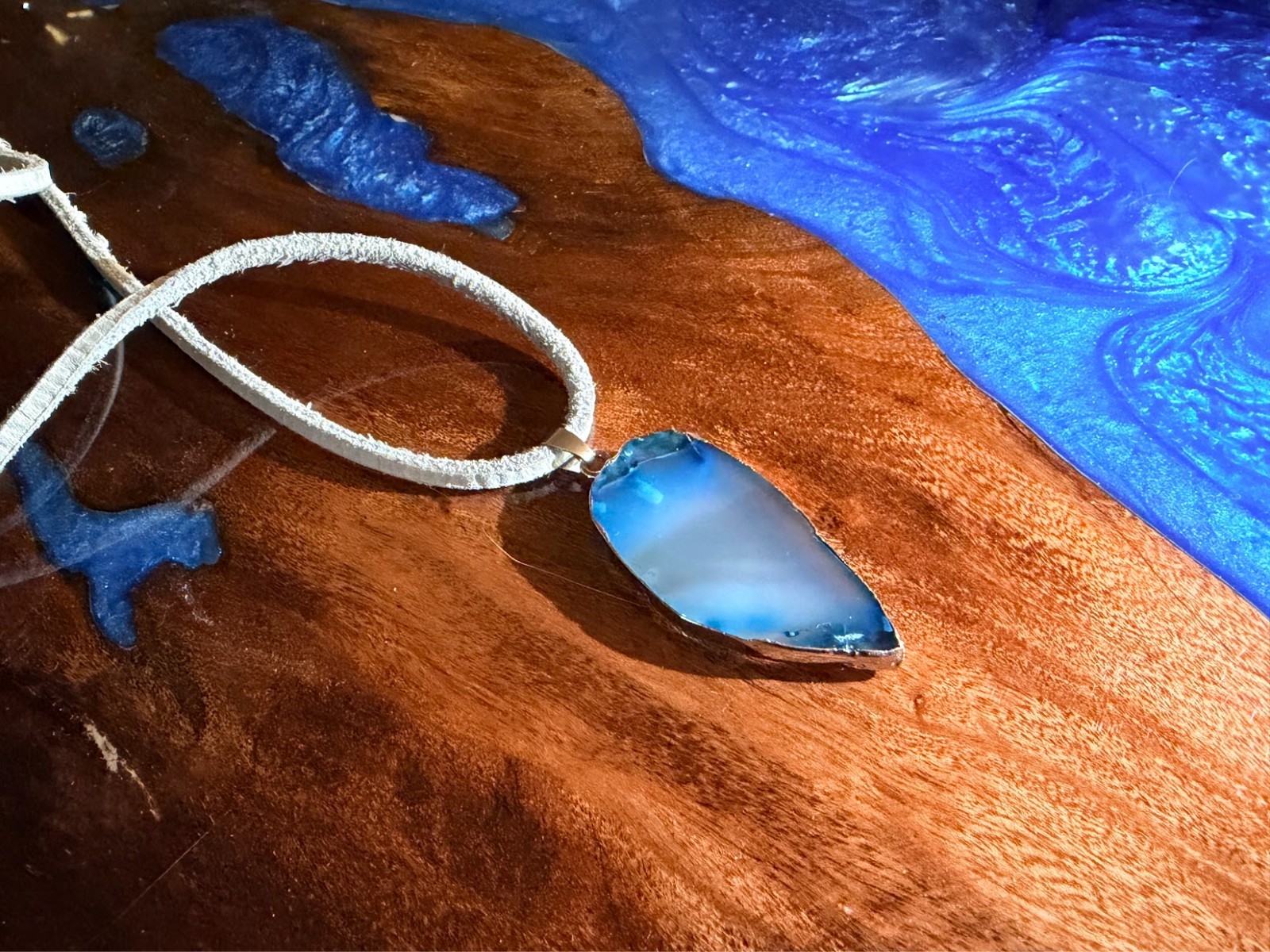 Semi-transparent blue slice agate necklace with grey faux-suede cord