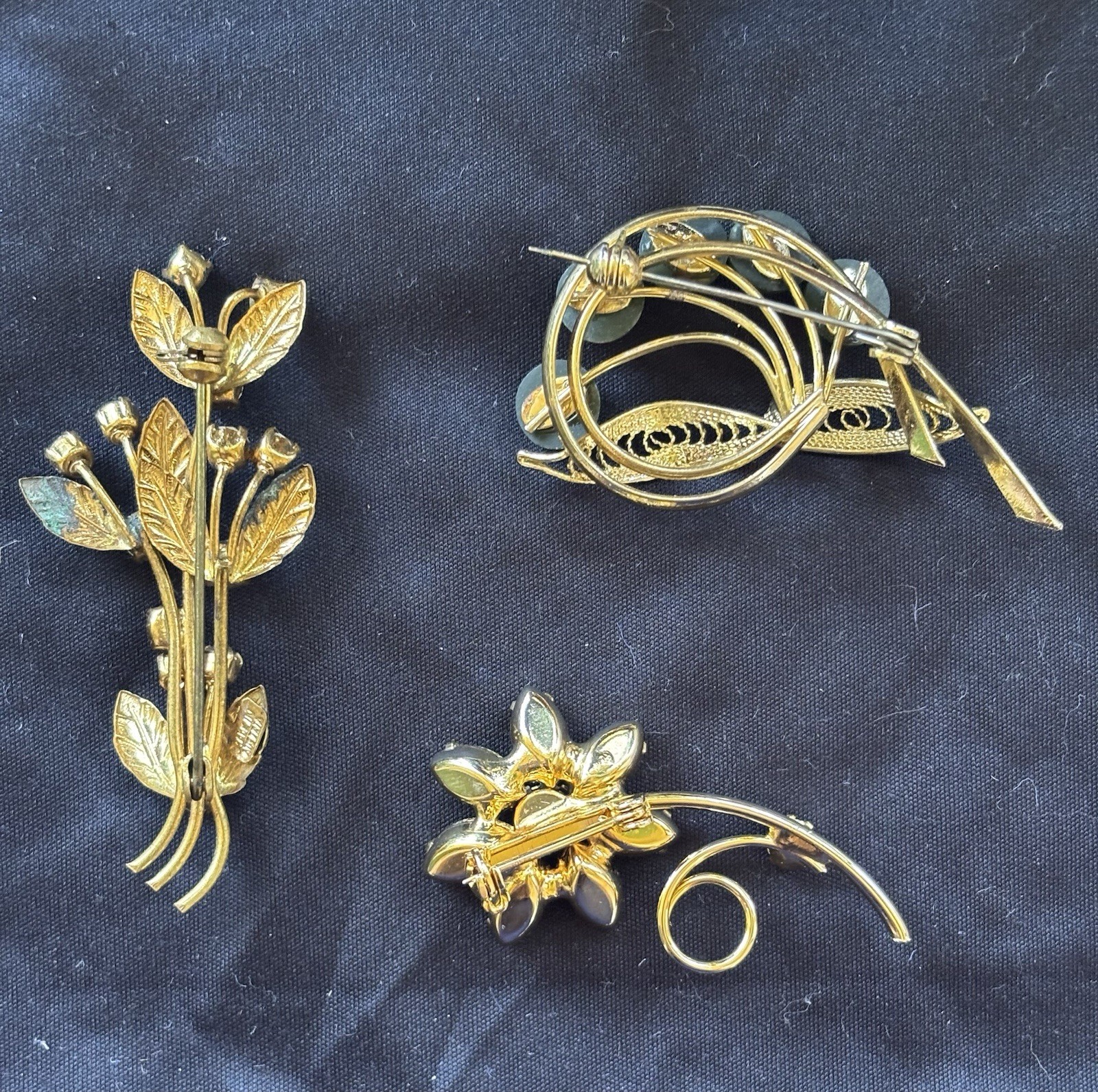 Lot of 3 gold tone floral brooches one signed