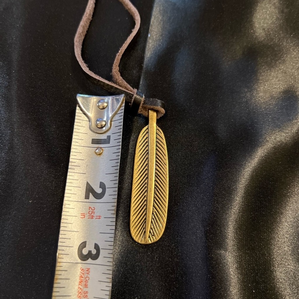 GUC- Lucky Brand brass like feather pendant on leather rope.