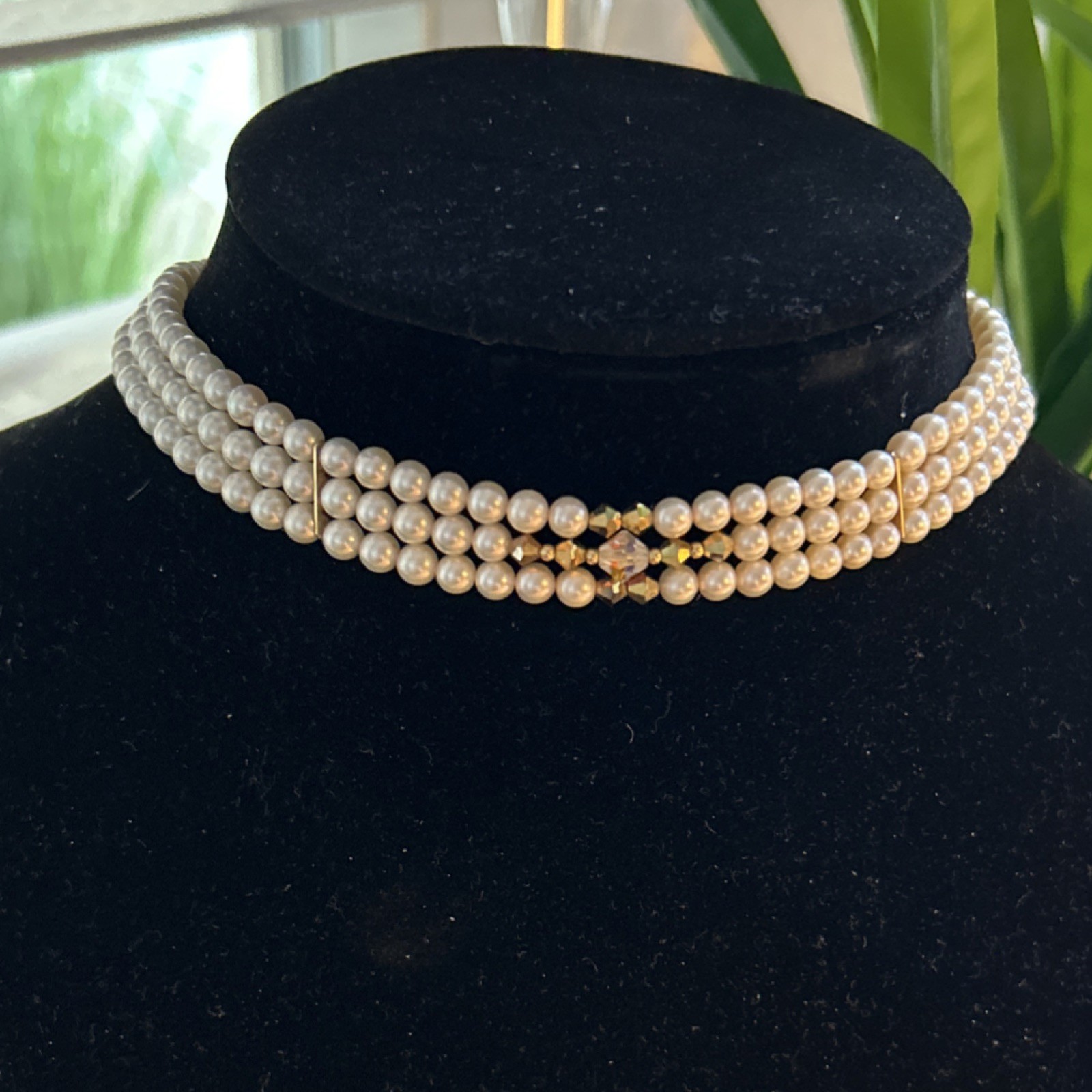 Triple strand Fresh Water Pearls accented with gold clasp and gold tone spacers.