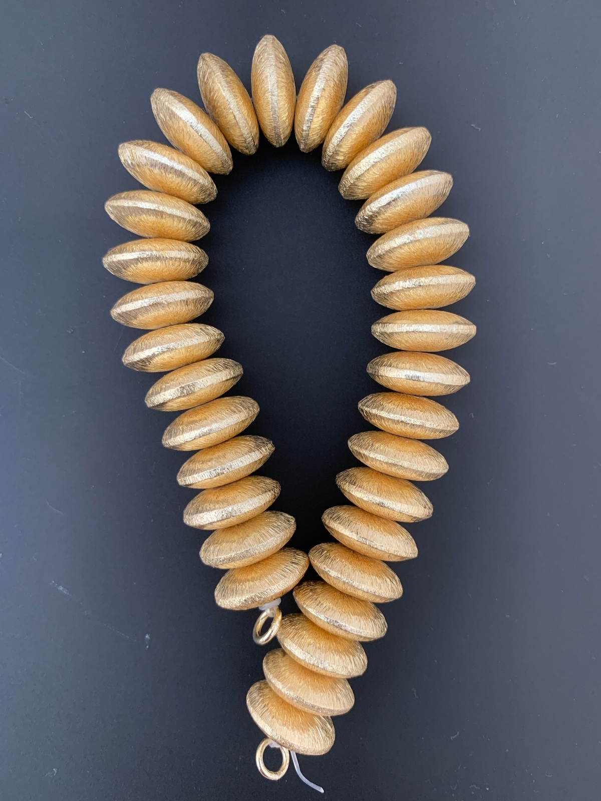 A Strand of Brushed Finish Disc Beads with Center Hole. Available in Gold Color,