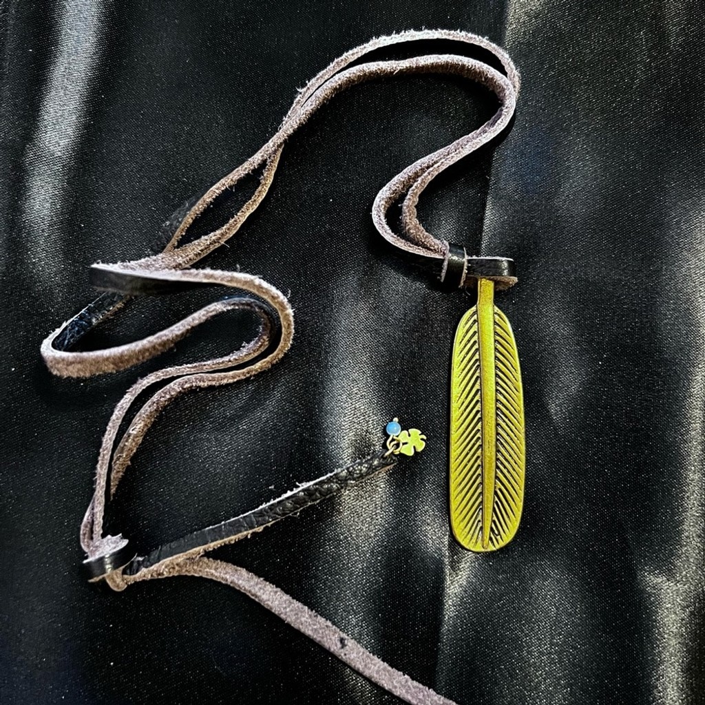GUC- Lucky Brand brass like feather pendant on leather rope.