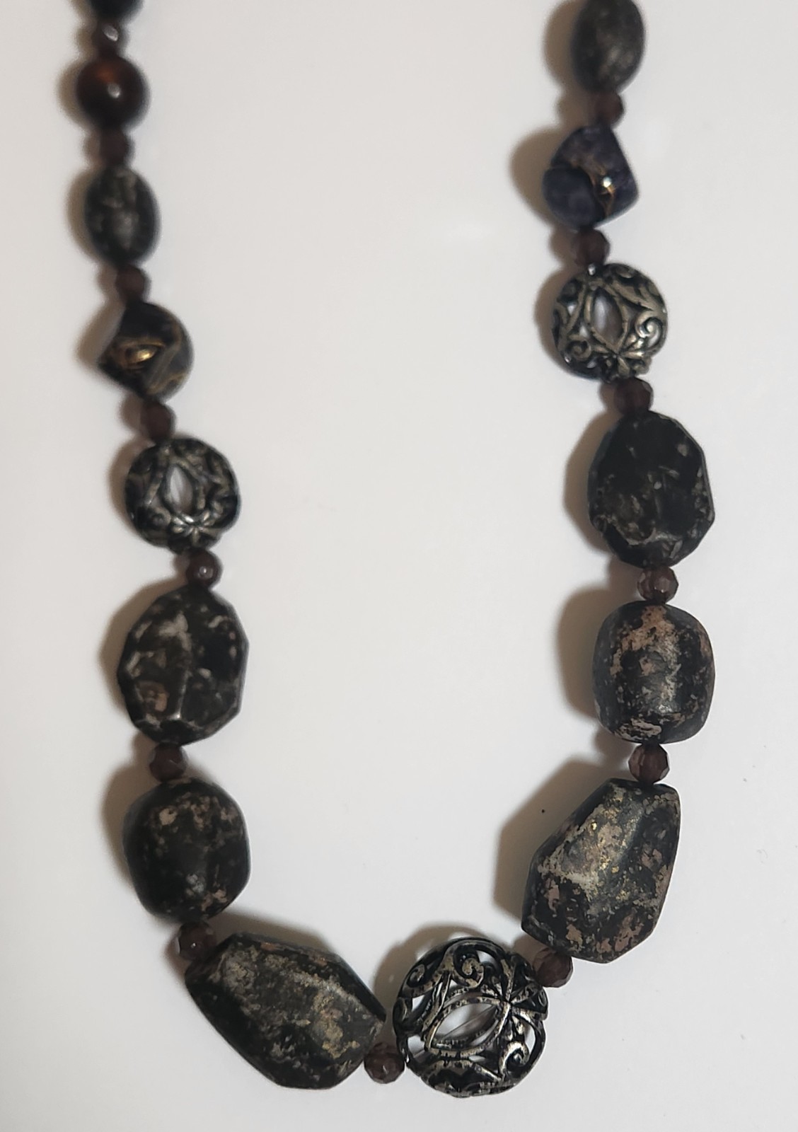 Handmade artisan necklace features chunky, speckled black beads and ornate.
