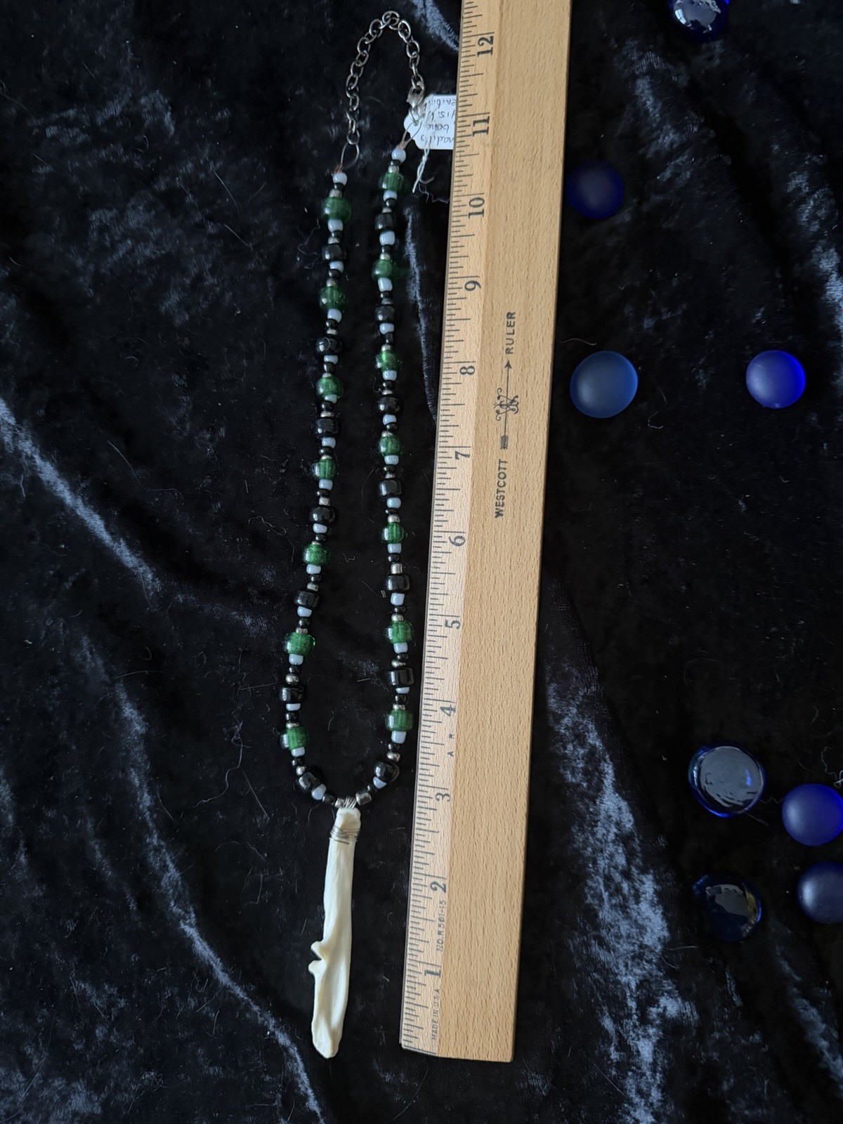 Armadillo leg bone necklace with green, black, gray, and silver glass beads