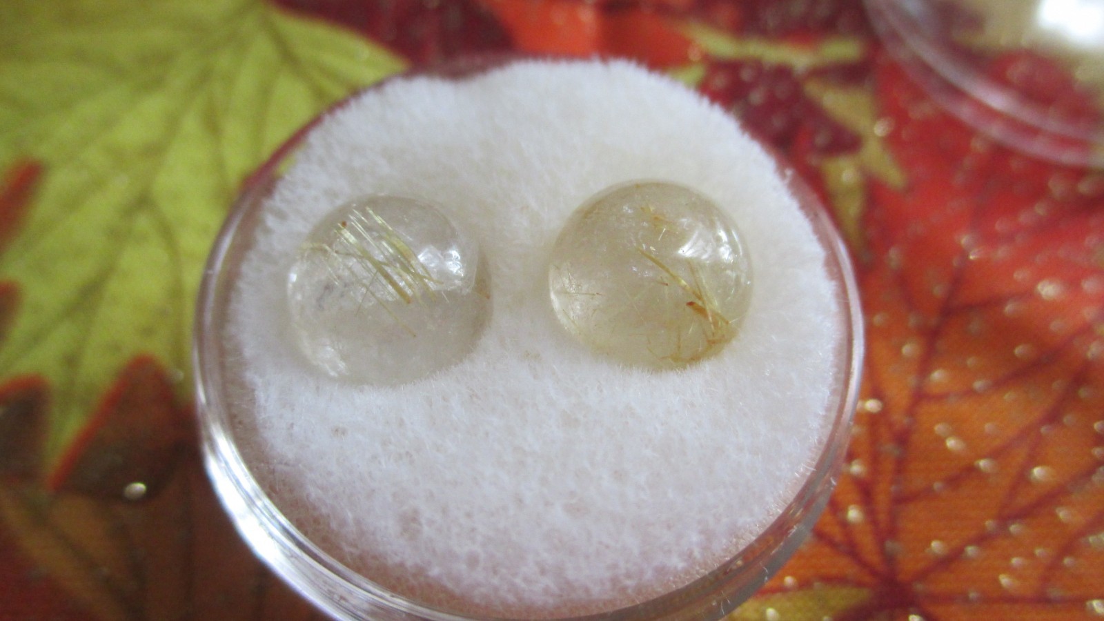 TWO OVAL CABOCHON CUT RUTILATED QUARTZ STONES IN GEM JAR