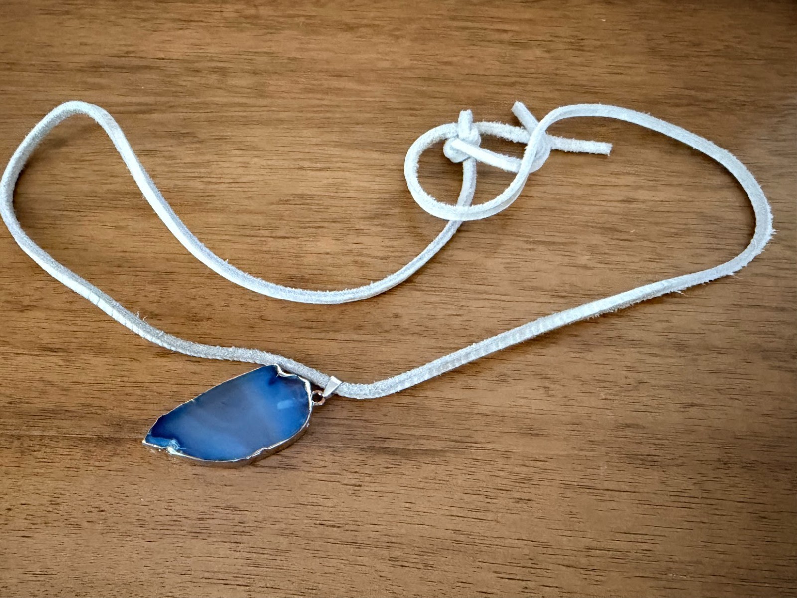 Semi-transparent blue slice agate necklace with grey faux-suede cord
