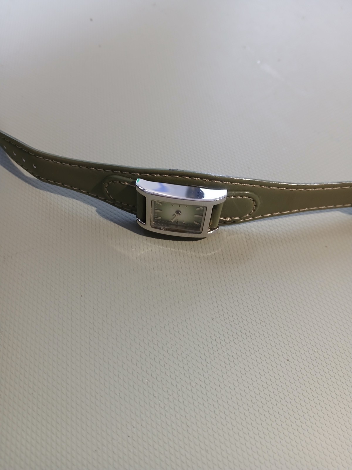 Ladies silver wathch with green face and one piece strap, new battery