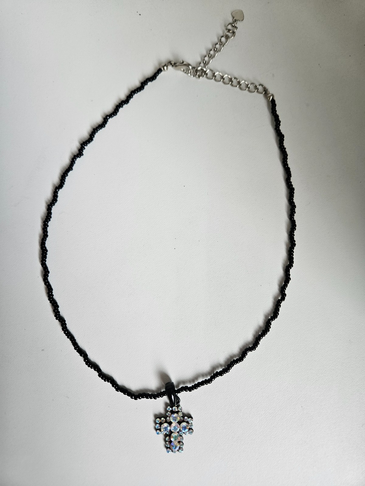 Cross pendant necklace with rhinestones on a black beaded strand