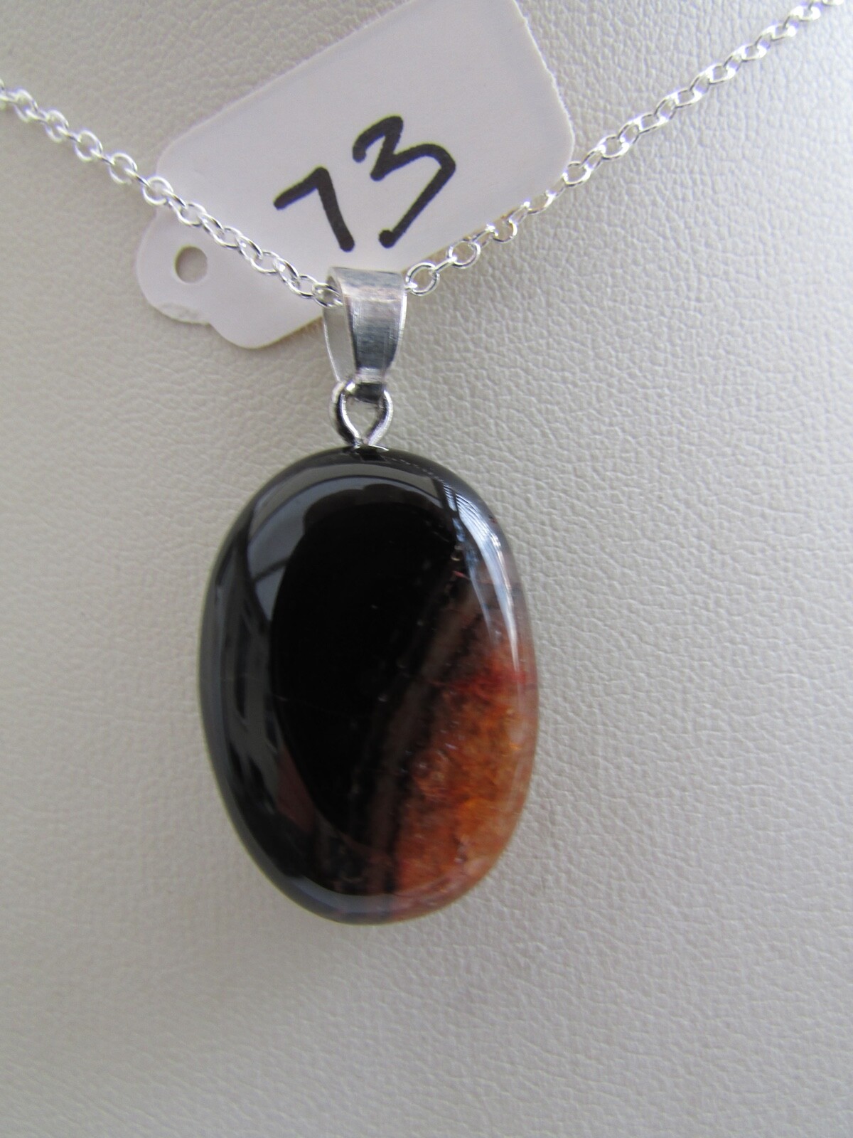 A BLACK/ORANGE DRUZY AGATE PENDANT ON A 18″ SILVER CHAIN. (28mm x 17mm) (73)