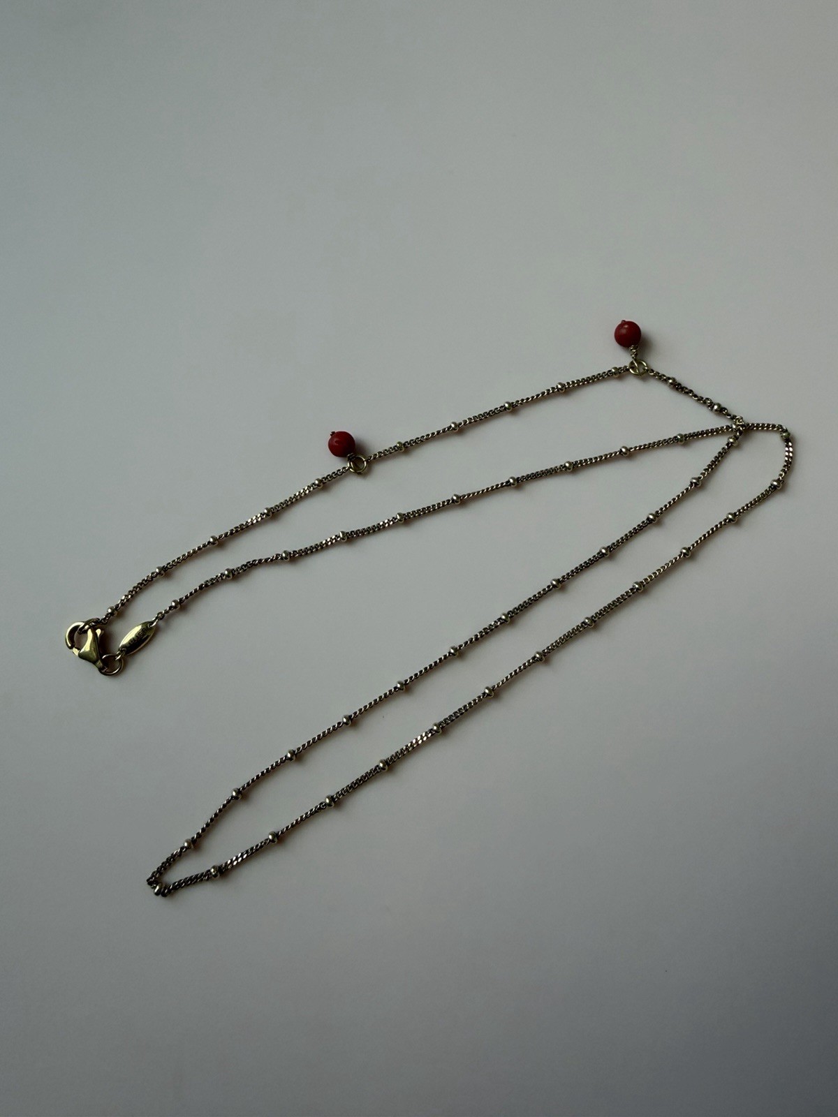 Gold over necklace chain coral adjustable maximum length 20 inches.