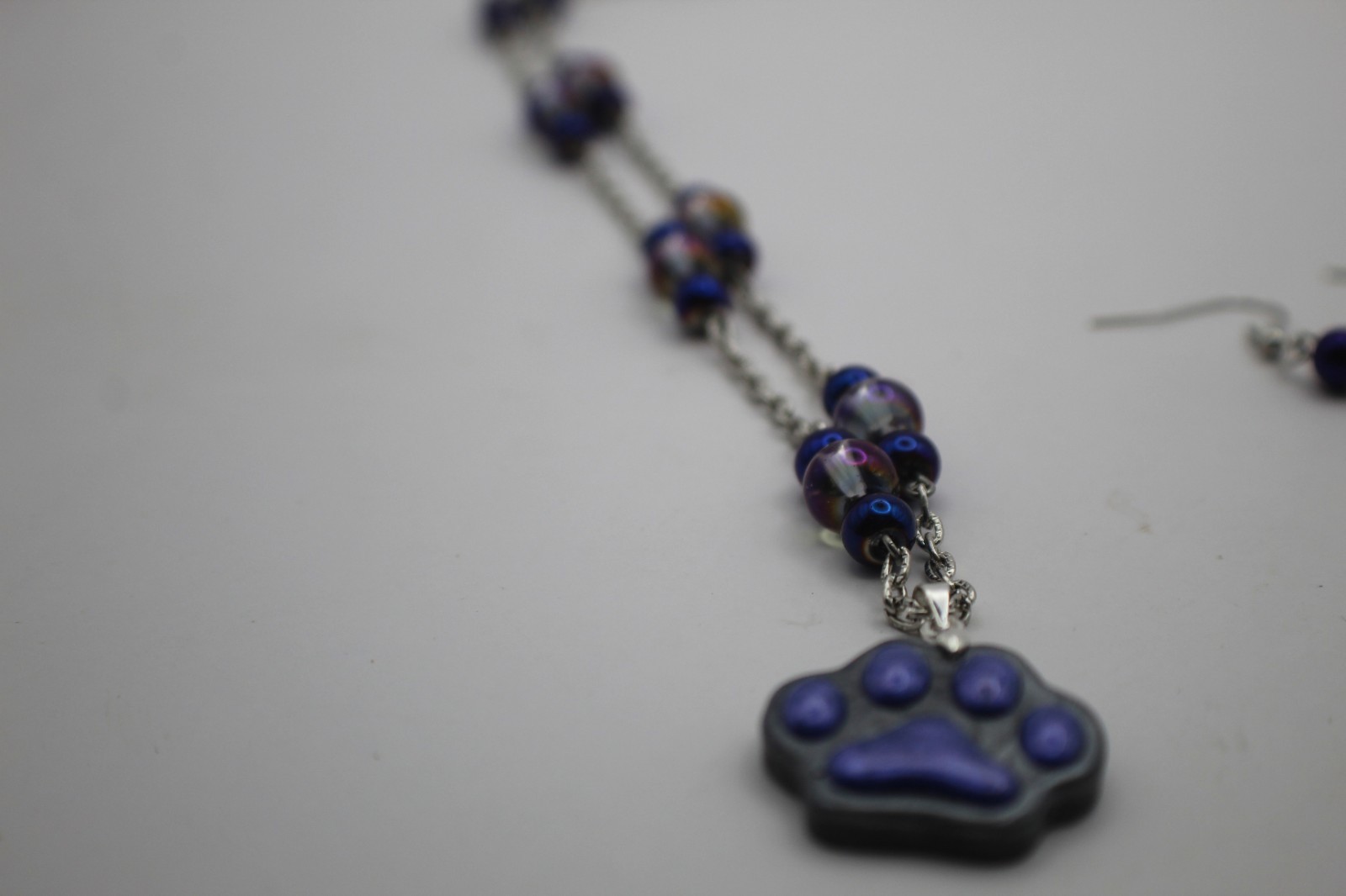 Cute Purple Paw Print Resin Pendant On A Beard Chain Necklace.