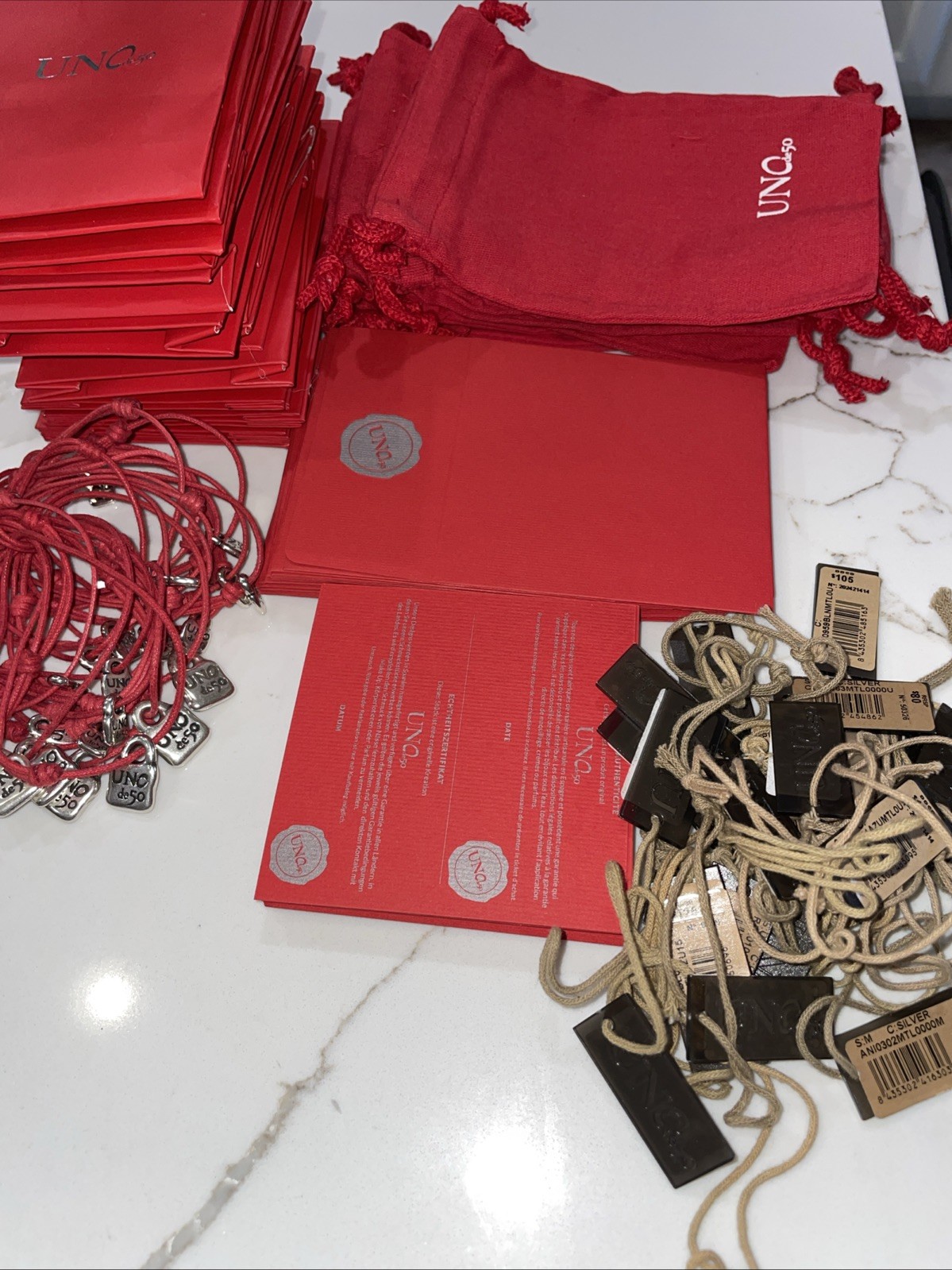 UNO de 50 packaging 10 Cloth Bags 18 Bags 25 Warranty, 25 Tags & 25 Bracelets