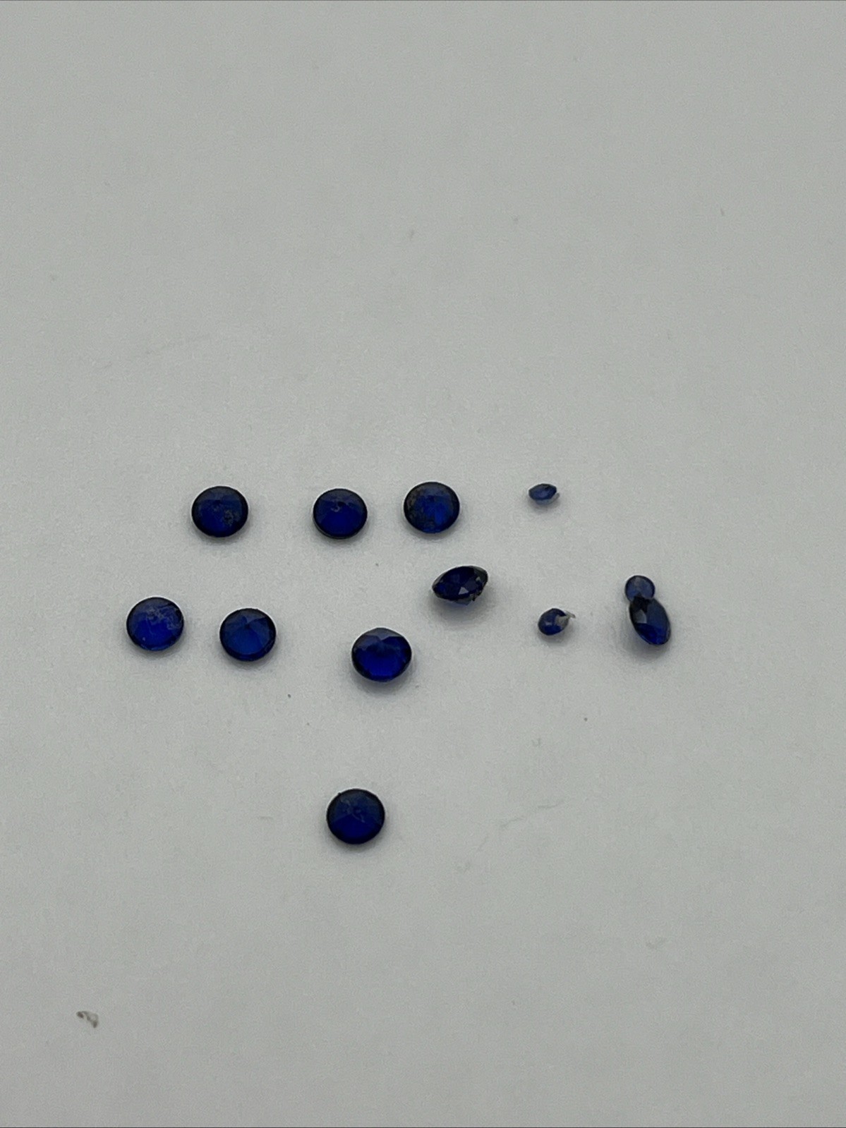 Nine 3 Mm And Three 1.5 Mm Round Faceted Synthetic Blue Sapphires
