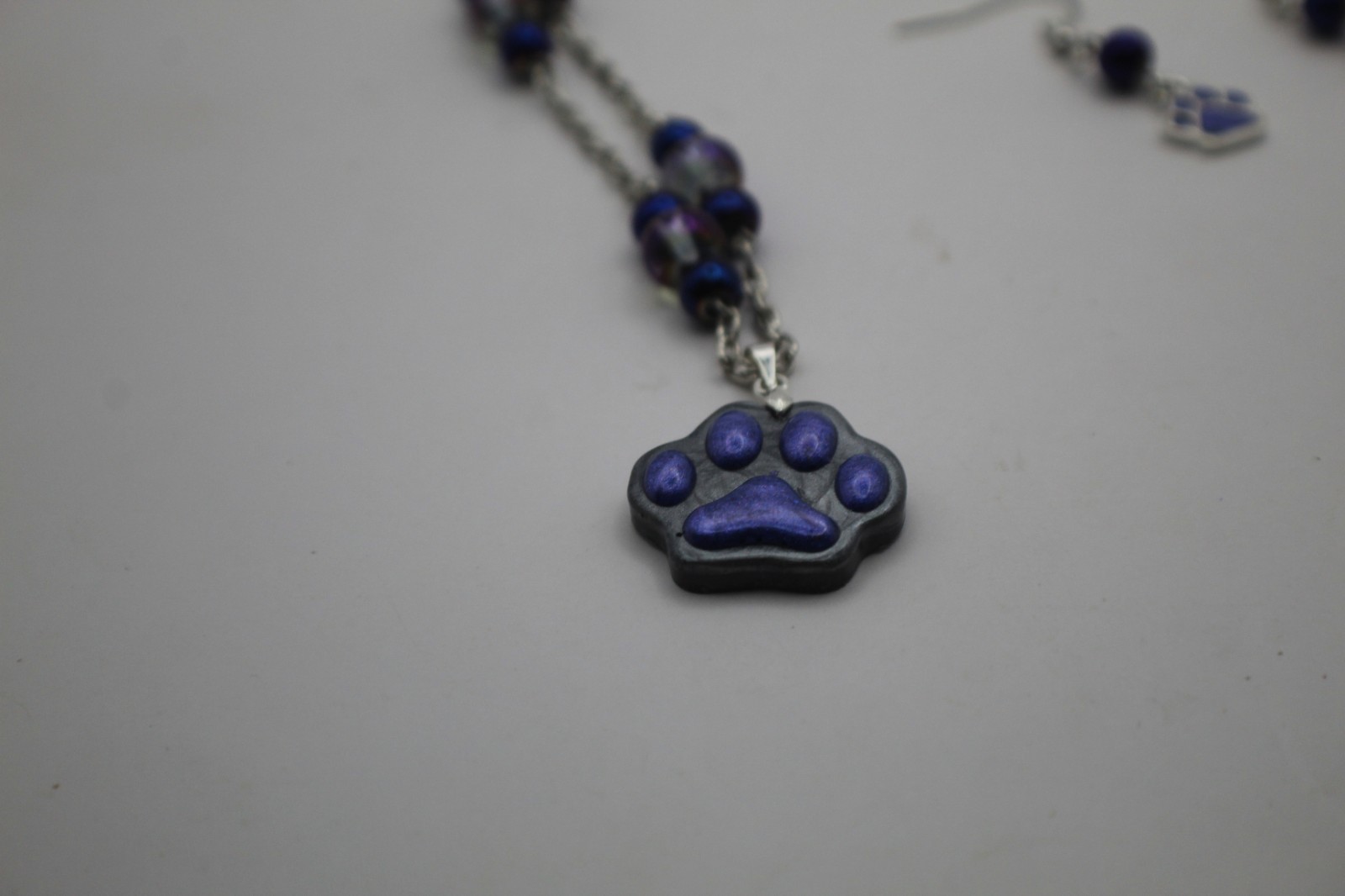 Cute Purple Paw Print Resin Pendant On A Beard Chain Necklace.