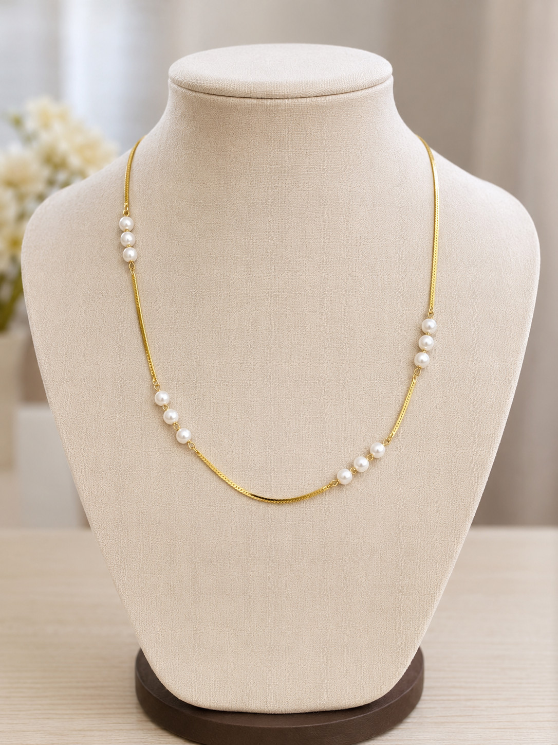 Asymmetrical station necklace featuring clusters of small, round white pearls