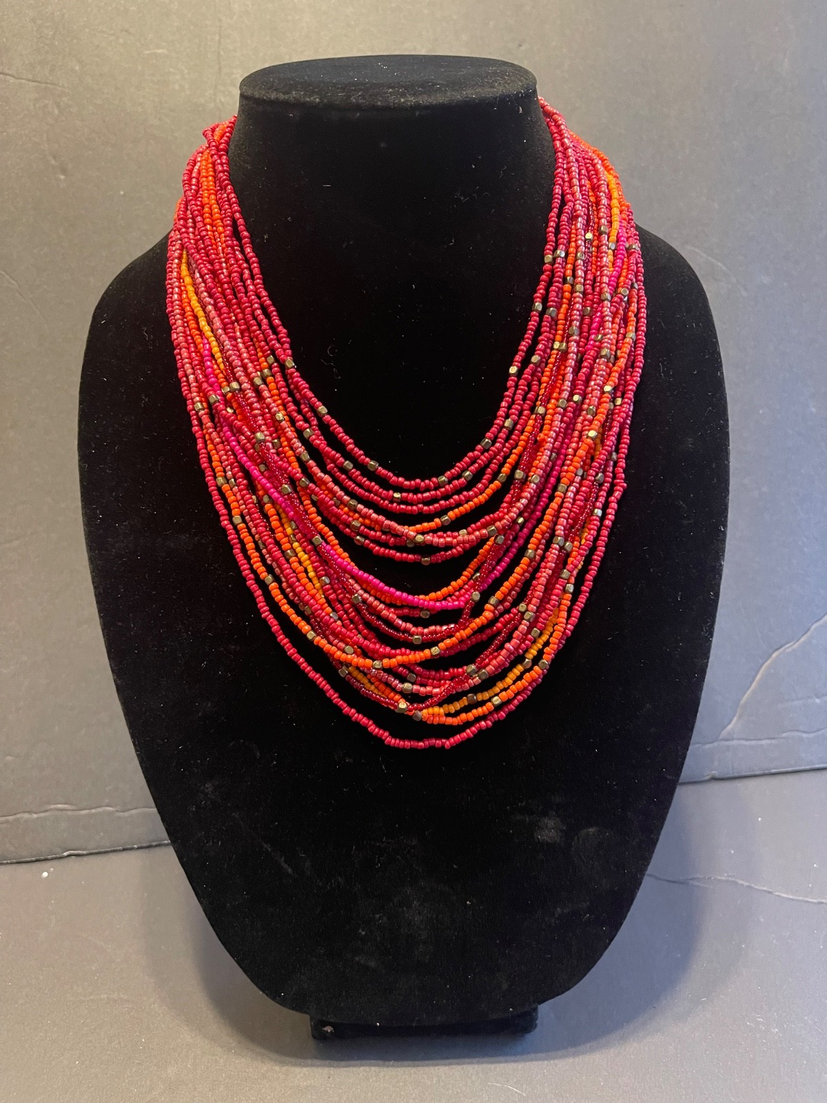 Multi strand bead necklace with warm red, orange and goldtone glass beads