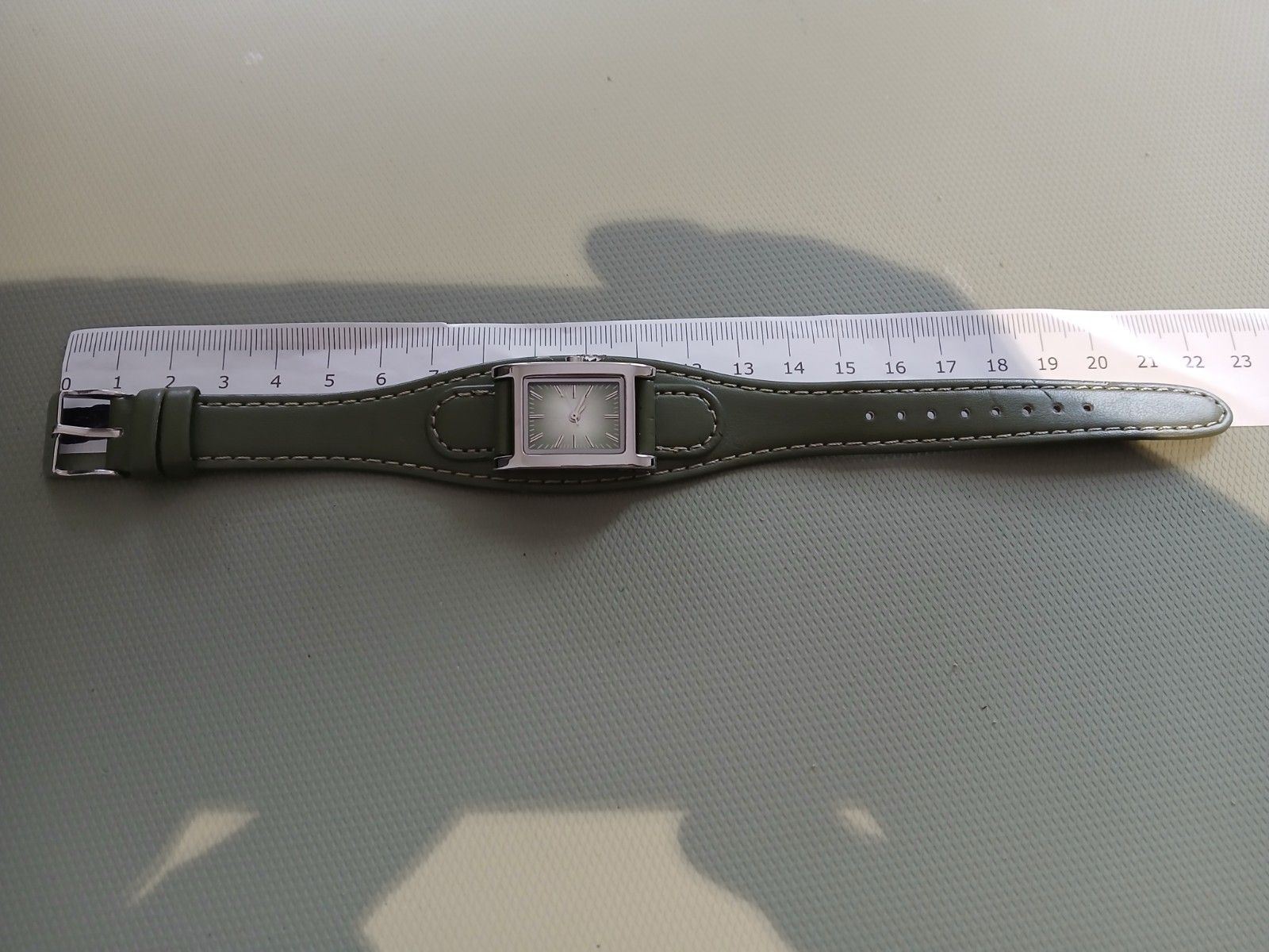 Ladies silver wathch with green face and one piece strap, new battery