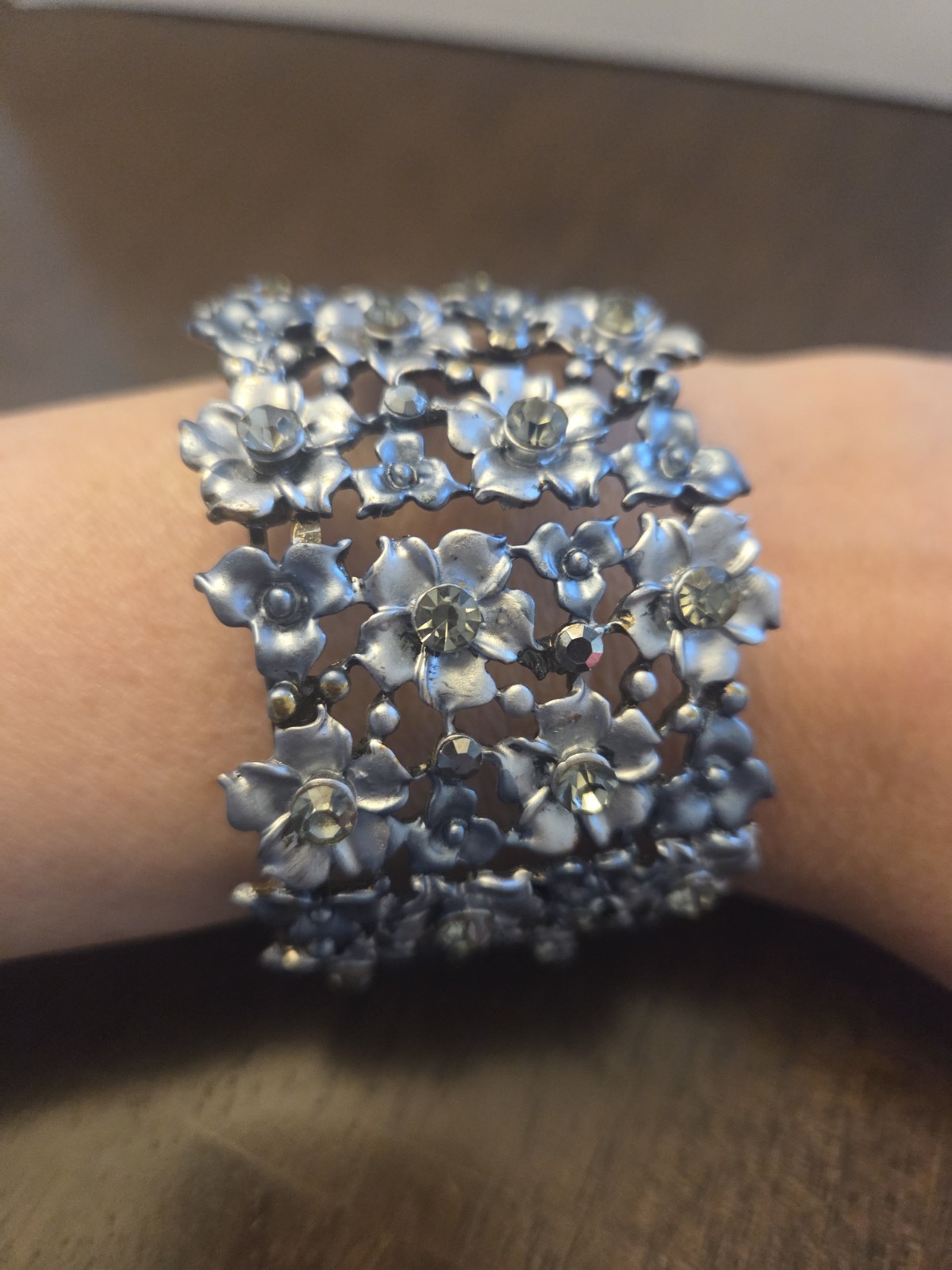 Silver 8 Inch. Metal Stretch Bracelet With Floral Design And Crystal Accents