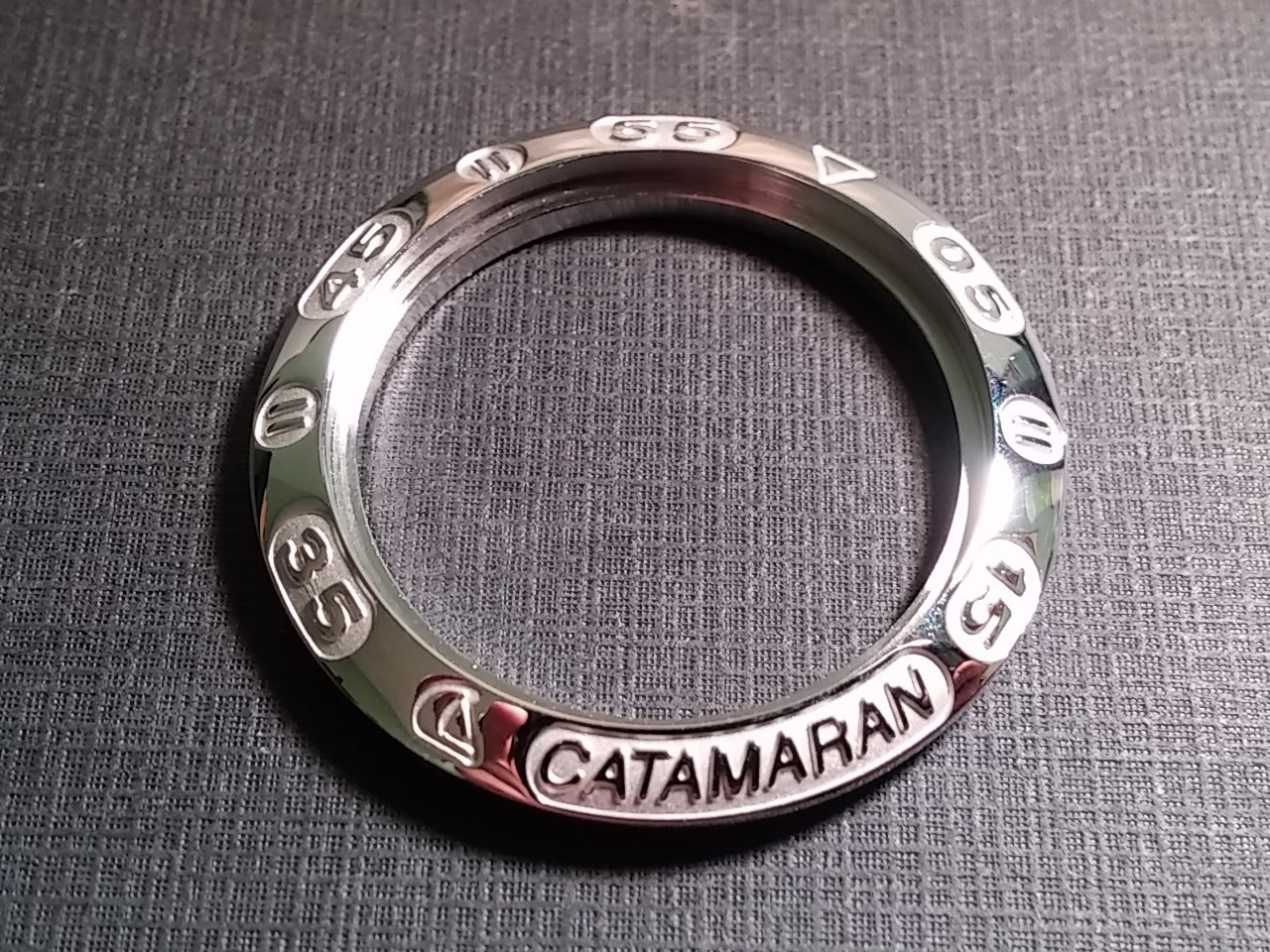 Catamaran bezel 28mm approx, S/S, NOS for watch repair or parts