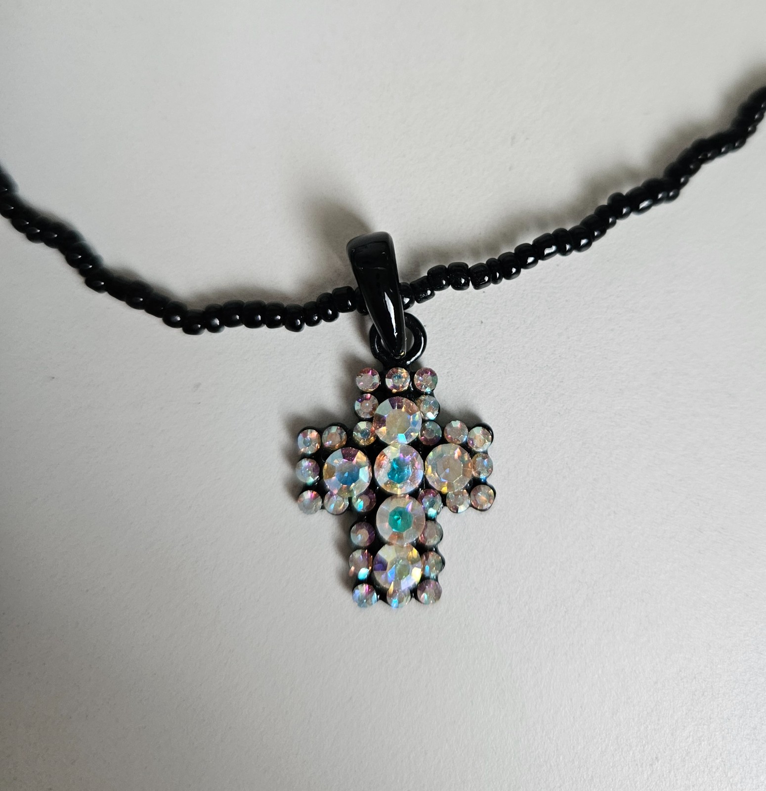 Cross pendant necklace with rhinestones on a black beaded strand