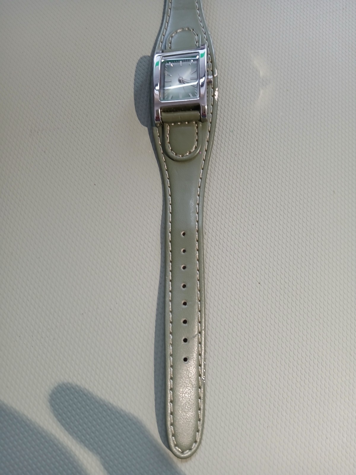 Ladies silver wathch with green face and one piece strap, new battery