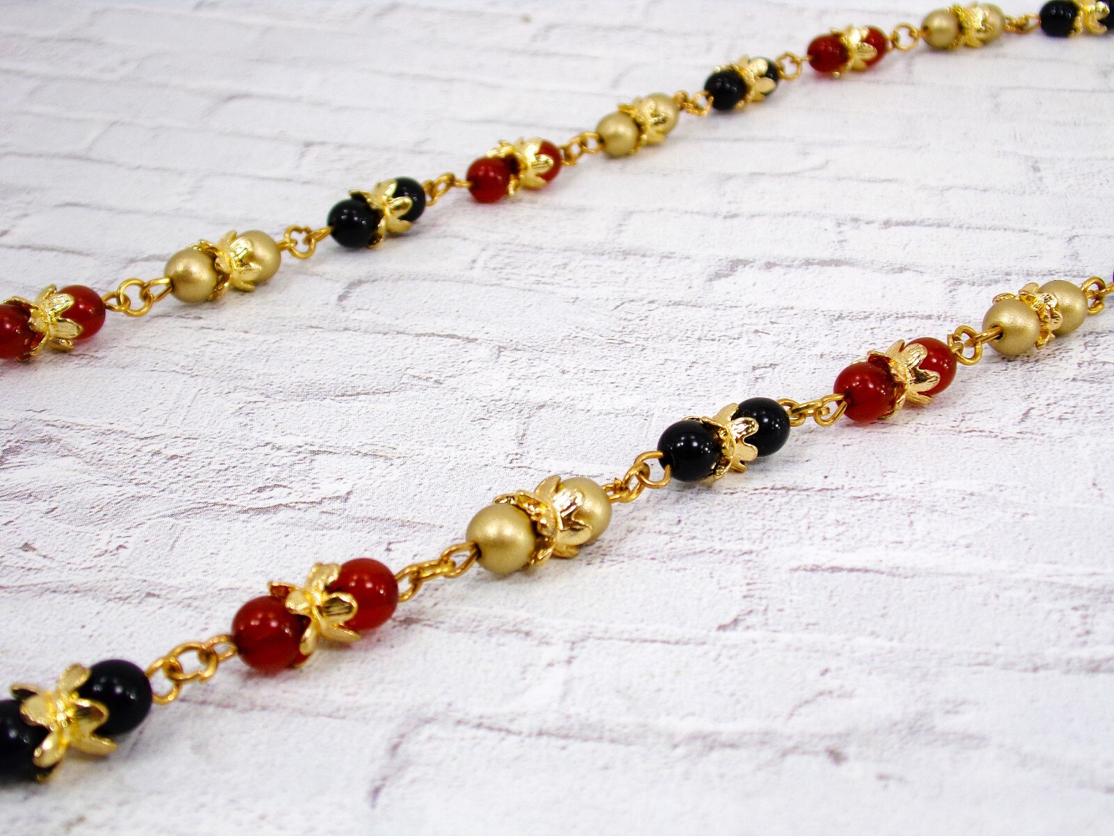 Multi color glass bead necklace with a mix of red, black, and gold colors New