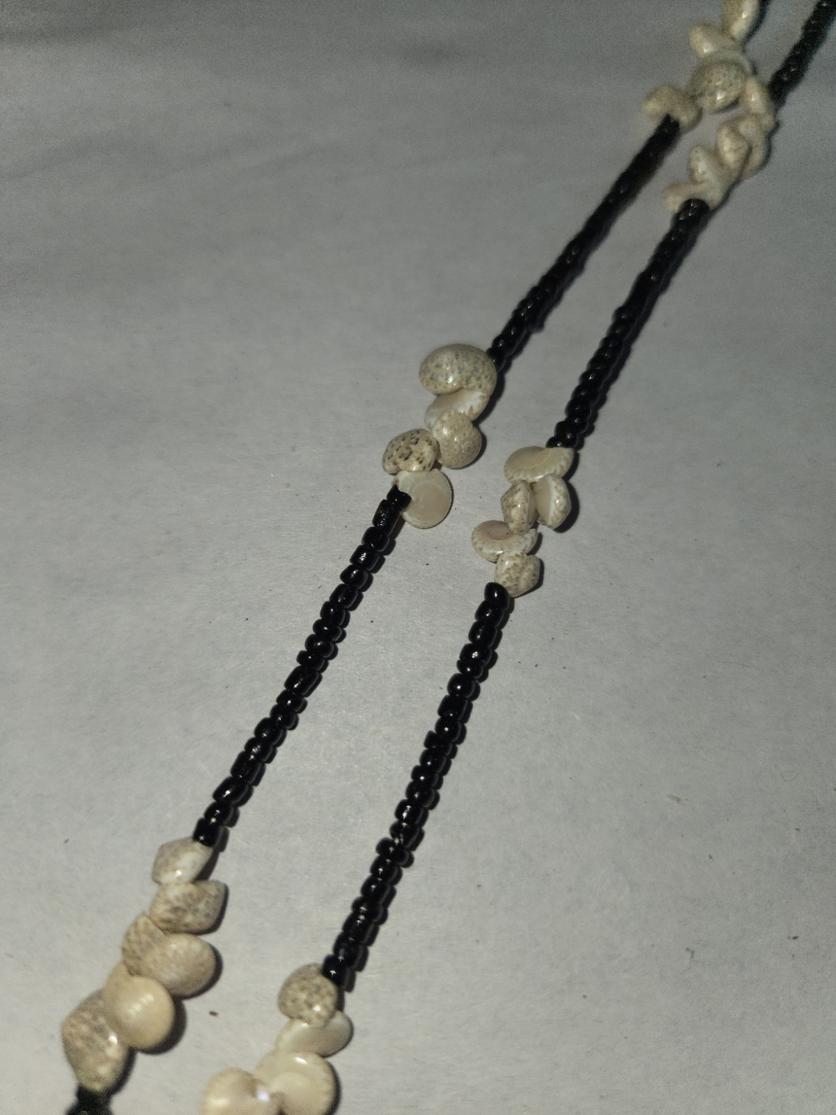 seashells With interspersed along rows of glossy black Beads…